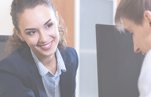 Smiling employee looks at colleague focusing on work item