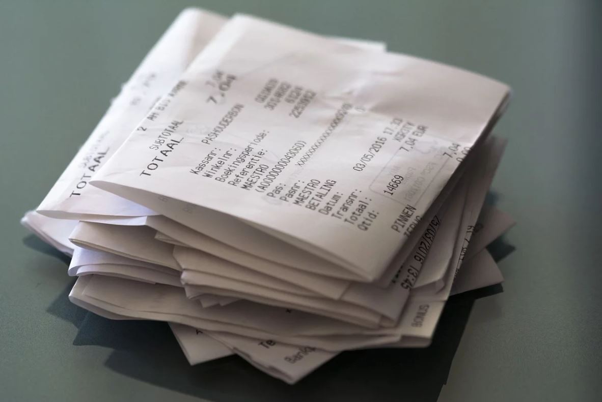 Stacked folded receipts on dark background