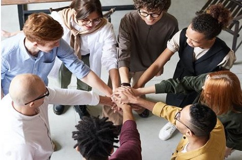 Group of people touching hands in a circle